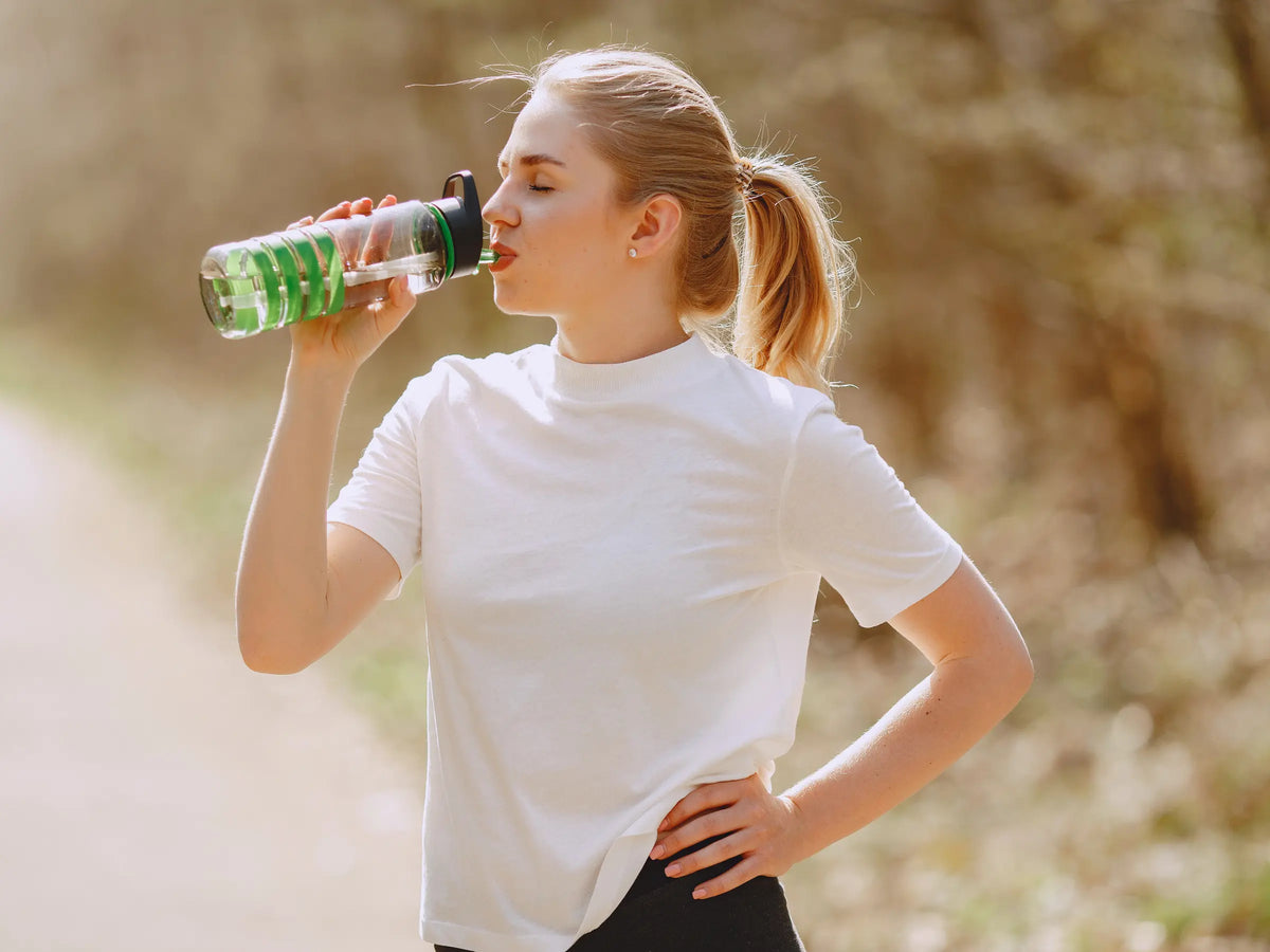 Femme sportive qui boit de l'eau 